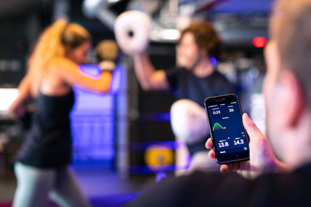 person holding a phone with a fitness GUI displayed