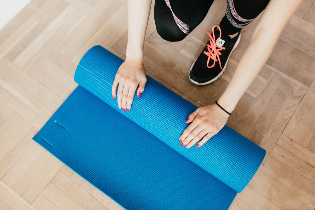 Lady rolling up  a yoga mat